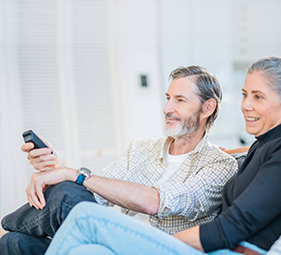 Husband holding remote smiling with wife